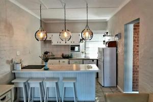 a kitchen with a large island with bar stools at Shepherd's Rest in Mossel Bay