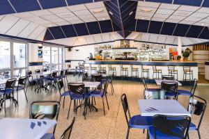 um restaurante com mesas e cadeiras e um bar em Azureva Ile d'Oleron em Grand-Village-Plage