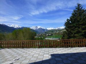 a wooden fence with snow capped mountains in the background at Hotel Beau Séjour in Aosta