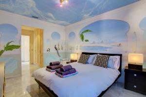ein Schlafzimmer mit einem großen Bett und einem Gemälde an der Decke in der Unterkunft Monte Paraiso Apt in Marbella