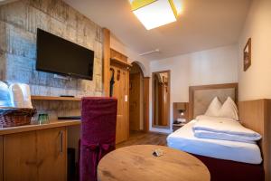 a room with a bed and a tv on a wall at Vogl's Nest in Fuschl am See