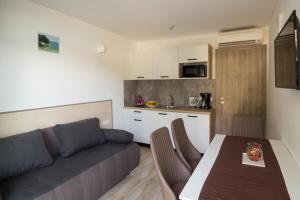 a living room with a couch and a table and a kitchen at Centinera Apartments in Banjole
