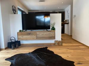 a living room with a large flat screen tv at Guatsi in Hollersbach im Pinzgau