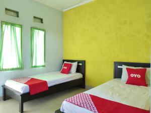 Tempat tidur dalam kamar di OYO 90333 Wisma Tenang Jaya Syariah