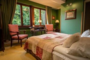 una camera da letto con pareti verdi e un letto con due sedie di Hotel Gródek a Cracovia
