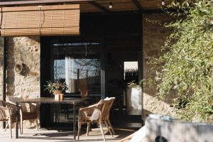 d'une terrasse avec une table, des chaises et une fenêtre. dans l'établissement Casa Diana B, à Sant Jordi Desvalls