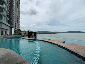 a swimming pool next to a large body of water at NASA Family Suite at Imperium Residence in Kuantan