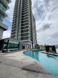 a building with a swimming pool in front of a building at NASA Family Suite at Imperium Residence in Kuantan
