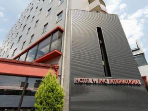 相模原市にあるホテル ウィングインターナショナル相模原の愛の翼国際を読む看板のある建物
