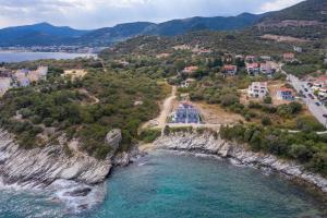 an aerial view of a resort on a cliff next to the ocean at MG Villas & Suites in Paleo Tsifliki