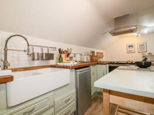 a kitchen with white cabinets and a sink at Five Elements Barn in Truro
