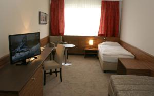ein Hotelzimmer mit einem Bett und einem TV in einem Zimmer in der Unterkunft Hotel Mühlviertler Hof in Schwertberg