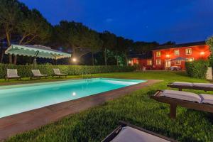 a swimming pool in the yard of a house at night at Coselli's luxury Villas in Capannori