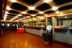 a restaurant with a bar with lights on the ceiling at Nan Chao Hotel in Phitsanulok