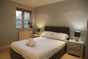 a bedroom with a bed with a towel on it at Letting Serviced Apartments - Sheppards Yard, Hemel Hempstead Old Town in Hemel Hempstead +29 photos