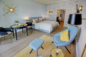 グリュックスブルクにあるfewo1846 Intermar - Marina del Rey - elegantes Studioapartment mit Meerblick und eigenem Strandkorbのベッド、テーブル、椅子が備わるホテルルームです。