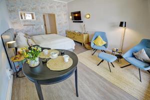 a living room with a bed and a table and chairs at fewo1846 - Marina del Rey - elegantes Studioapartment mit Meerblick und eigenem Strandkorb in Glücksburg +14 photos