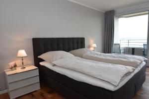 - une chambre avec 2 lits avec des draps blancs et une fenêtre dans l'établissement fewo1846 - Intermar Lina K - Luxuriöses Apartment im 6 OG mit Balkon und Meerblick, à Glücksburg