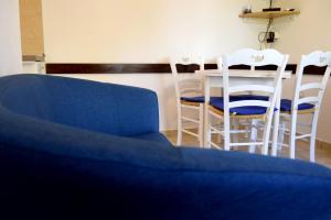 a living room with a blue couch and a table and chairs at MiraMar Gardenn Apartmment in Rab