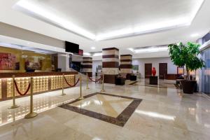 eine Lobby mit einem Wartebereich mit einer Pflanze in der Unterkunft Ramada Plaza by Wyndham Veracruz Boca del Rio in Veracruz