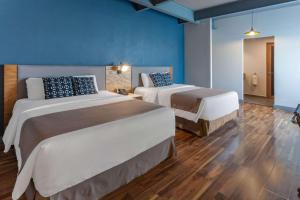 Postel nebo postele na pokoji v ubytování TRYP by Wyndham San Luis Potosi Hotel & Suites