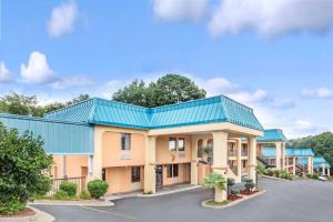 un hotel con techo azul y aparcamiento en Super 8 by Wyndham Forest Park, en Forest Park