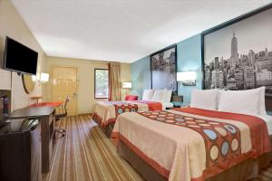 a hotel room with two beds and a flat screen tv at Super 8 by Wyndham Forest Park in Forest Park
