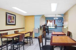 a dining room with wooden tables and chairs at Super 8 by Wyndham Forest Park in Forest Park