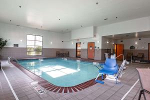 a large swimming pool with a blue chair in it at Wingate by Wyndham Parkersburg - Vienna in Parkersburg
