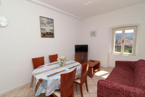 a living room with a dining room table and a couch at Apartment Lepur Slano in Slano