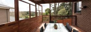 patio con mesa y sillas en el balcón en Newly Built - Blue on Albion, en Katoomba