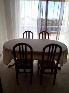 een tafel en stoelen met een tafel en een raam bij cantinho do mar in Albufeira