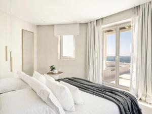 a hotel room with a bed and a window at Mykonos Earth Suites in Mikonos