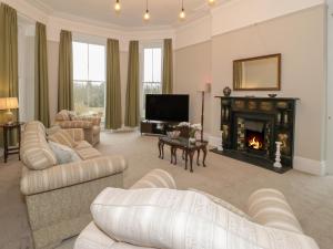 a living room with a couch and a fireplace at 1 Tyn Y Caeau Apartment in Menai Bridge
