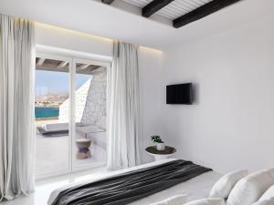a bedroom with a bed and a view of the ocean at Mykonos Earth Suites in Mýkonos City