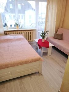 a bedroom with two beds and a couch and a table at POKOJE GOŚCINNE BRYZA in Mielno