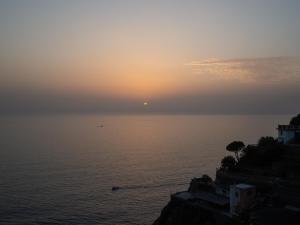 a sunset over the ocean with the sun in the distance at Le Terrazze di katia apartment in Riomaggiore