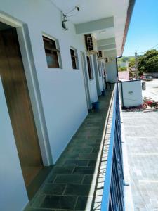 um corredor de uma casa com piso em azulejo e uma cerca em Hotel Pousada Garoupas em São Sebastião