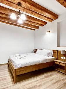 ein Schlafzimmer mit einem großen Bett und Holzdecken in der Unterkunft CERO Brasov in Braşov