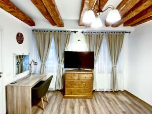 a room with a desk with a television and curtains at CERO Brasov in Braşov