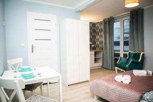 a small room with a bed and a table and a desk at Zajazd Bombonierka in Wikno