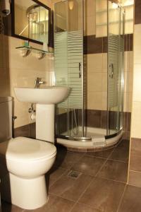 a bathroom with a toilet, sink, and shower at Rea Hotel in Heraklio