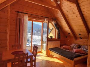 sypialnia w drewnianym domku z łóżkiem i stołem w obiekcie Grażynka w Zakopanem