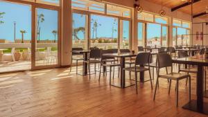 a restaurant with tables and chairs and large windows at Azul Beach Resort Montenegro by Karisma - All Inclusive in Ulcinj