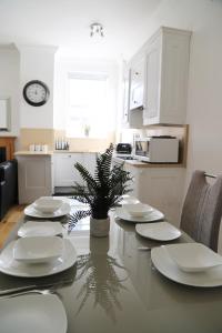 una cocina con una mesa con platos y una planta en Letting Serviced Apartments - Guards View, Windsor, en Windsor
