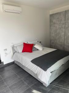 Schlafzimmer mit einem großen Bett und einem roten Kissen in der Unterkunft La Filanda di Viano in Villa in Tremezzo