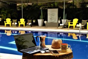 a laptop computer sitting on a table next to a pool at Hotel Boutique Budapez in Honda