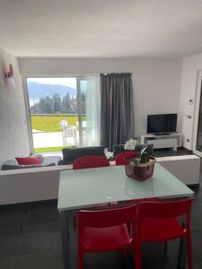 ein Wohnzimmer mit einem Tisch und roten Stühlen in der Unterkunft La Filanda di Viano in Villa in Tremezzo