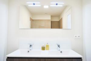 a bathroom with two sinks and a mirror at Diamant 2BR in Brussels +15 photos