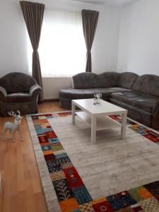a living room with a couch and a coffee table at Apartament Happynest in Predeal
